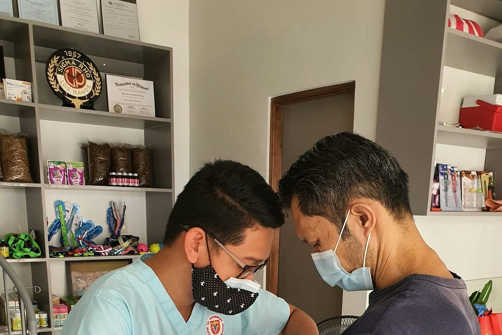 Veterinario atendiendo a un perro junto a su dueño